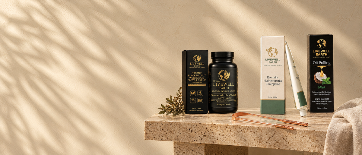The LiveWell bundles on a travertine console in late sun: Black Walnut Wormwood Clove and Garlic drops and Herbal Gut Complex, Evermint Hydroxyapatite Toothpaste, Oil Pulling Mint and the copper tongue cleaner
